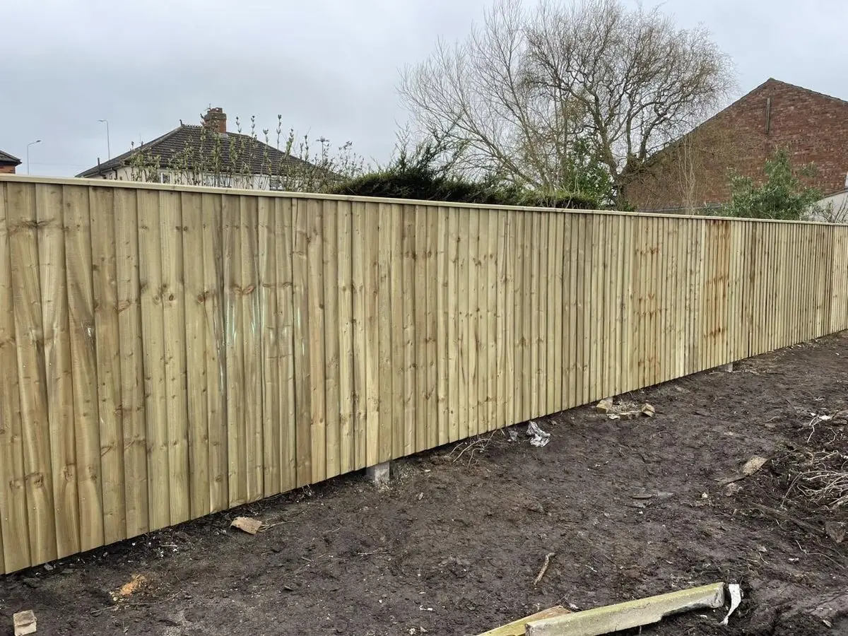 Long run of new close-board feather-edge fencing with capping rail