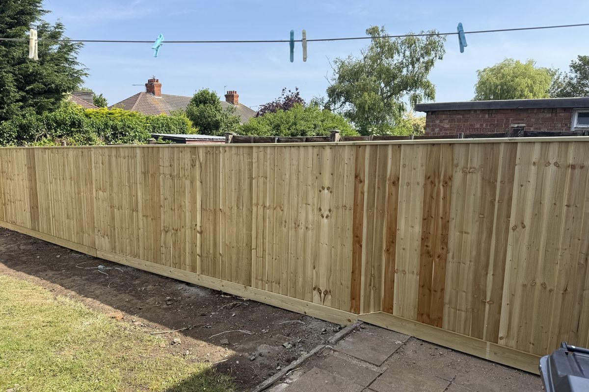 The finished garden with new feather-edge fencing and a tidy lawn