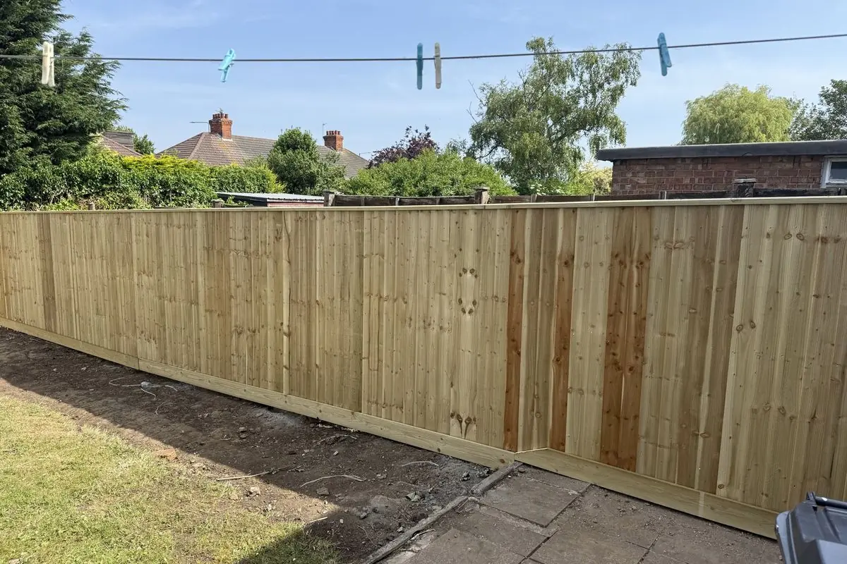 The finished garden with new feather-edge fencing and a tidy lawn