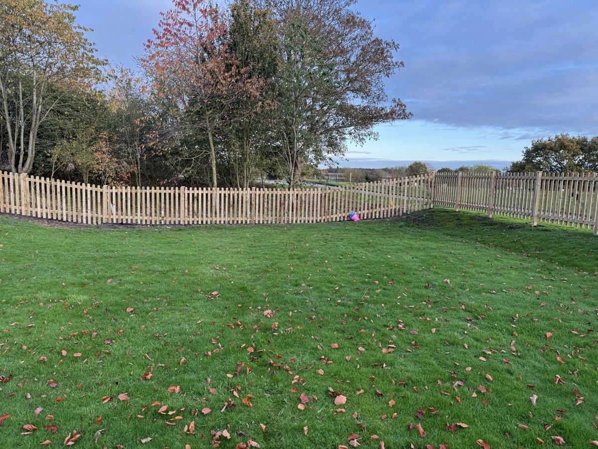 Timber picket fencing around a large lawned garden