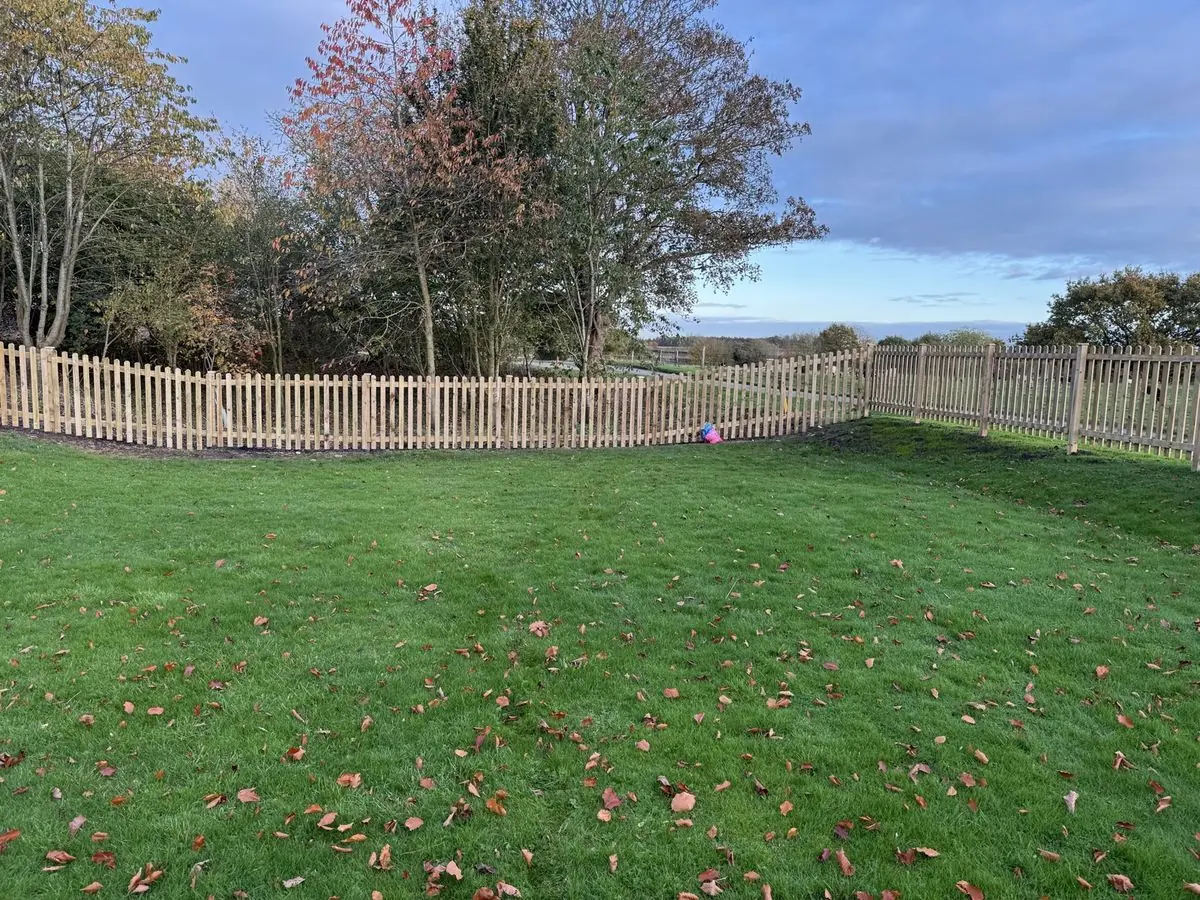Timber picket fencing around a large lawned garden