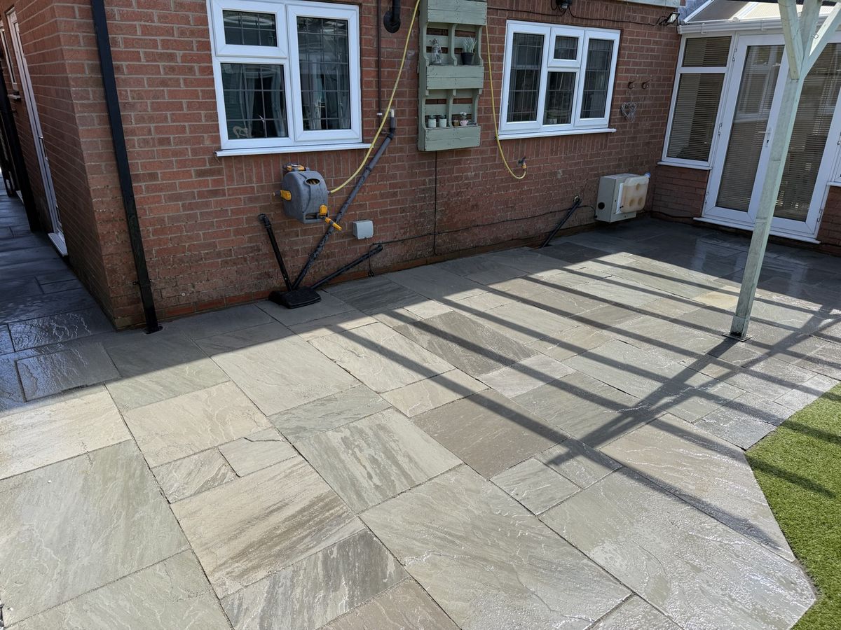 Wraparound Indian sandstone patio laid to the rear of a house