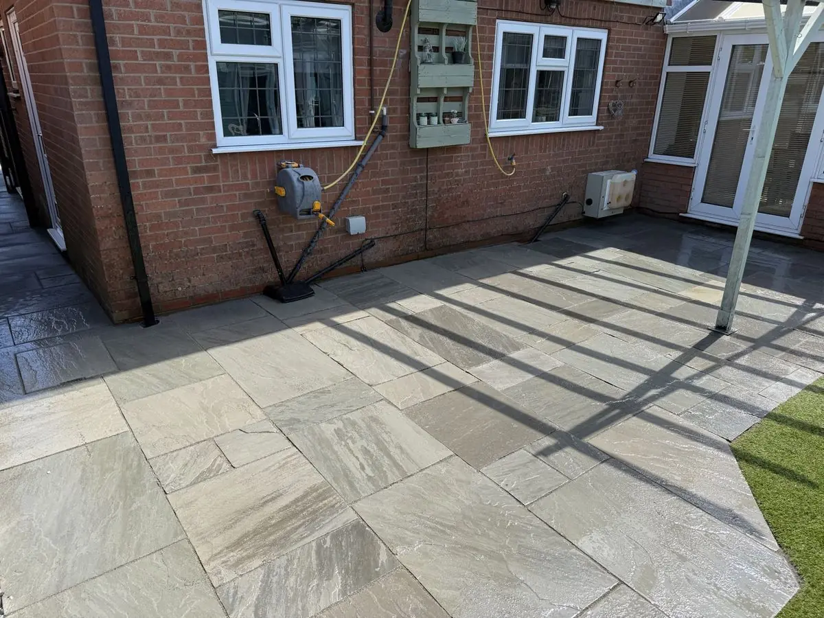 Wraparound Indian sandstone patio laid to the rear of a house