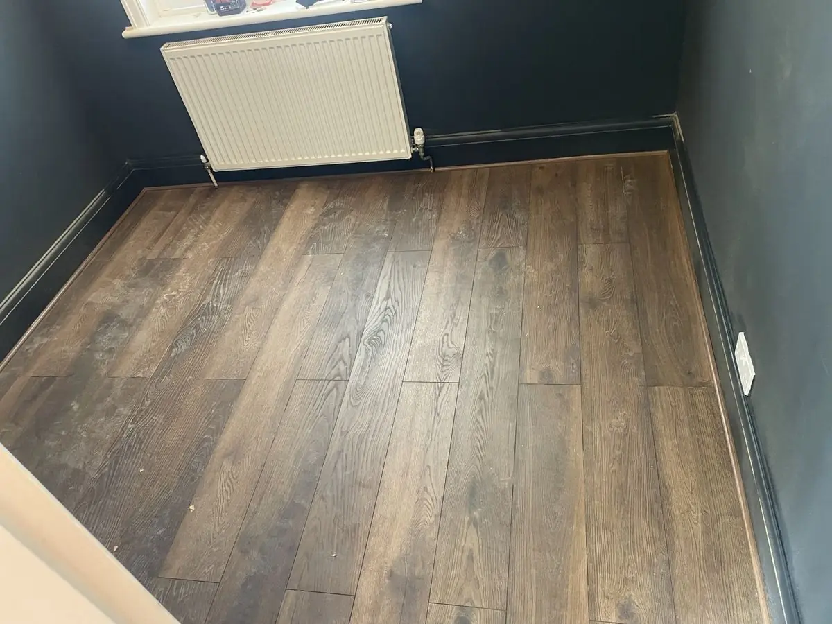 Dark engineered wood flooring in a room with deep navy walls
